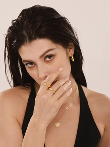 Close-up of minimalist gold plated stainless steel teardrop ring on a model