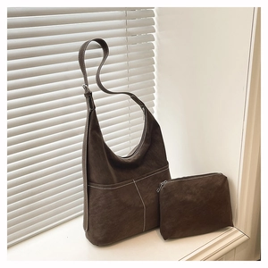 Détail du sac hobo en faux daim marron foncé avec coutures blanches et petite pochette