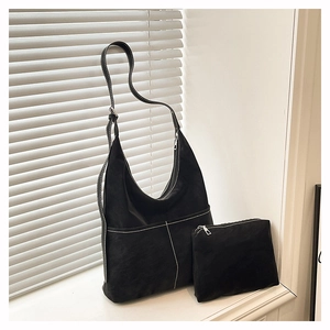 Détail d'un ensemble cabas hobo noir avec surpiqûres contrastées et pochette zippée