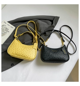 Detail of yellow and black ostrich leather texture underarm bags with gold chain