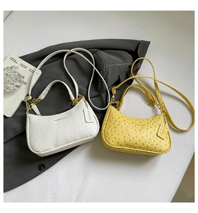 Detailed macro view of ostrich texture on faux leather shoulder bags in white and yellow