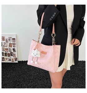 Dettaglio borsa tote rosa con stelle, ciondolo a nuvola e catena dorata elegante