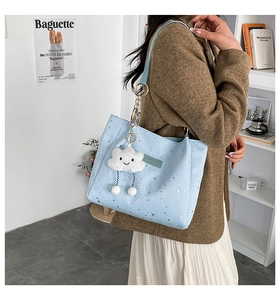 Light blue tote bag with silver star prints and a plush cloud charm accessory