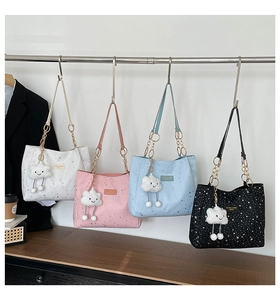 Detail of star-patterned tote bags in four colors with plush cloud charms and chain straps