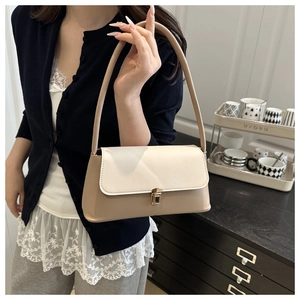 Detail of a chic two-tone underarm bag with khaki and cream leather and metal clasp