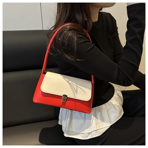Close-up of red and cream contrast leather underarm bag with gold metal buckle
