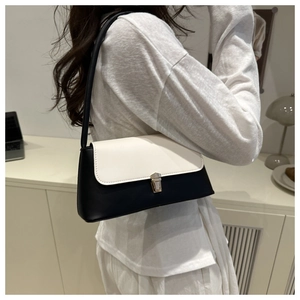 Detail showing the contrast black and white shoulder bag with silver metal buckle closure