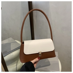 Detail of minimalist leather shoulder bag with white flap, brown body and gold buckle