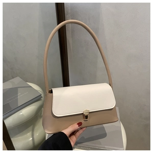Detail of color-block baguette bag with cream flap and metallic push-lock closure