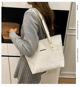 Detail of white marble pattern tote bag with leather texture and metal bar ornament