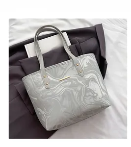 Detail shot of marble textured tote bag with elegant gold metal bar accent and gray patterns