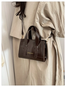 Close-up of a dark brown oil wax leather handbag with golden FASHION & BAGS lettering