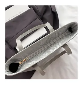 Close-up of smooth gold metal zipper and marble pattern lining inside grey tote bag