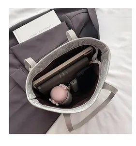 Top view of spacious white tote bag interior with durable brown lining and daily essentials