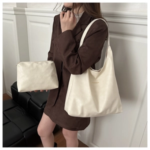 Detail of cream white tote bag set with pleated texture and fashion lettering for commuting