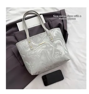 Detailed comparison showing large capacity of marble tote bag versus a smartphone