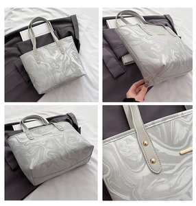 Detail of marble texture tote bag with gold hardware and reinforced stitching on handles