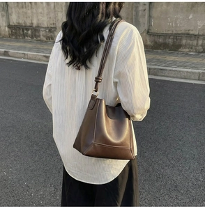 Detailed view of the dark brown matte leather tote with structural stitching and knotted strap