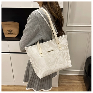 Detail of white marble textured tote bag showing long shoulder straps on a model