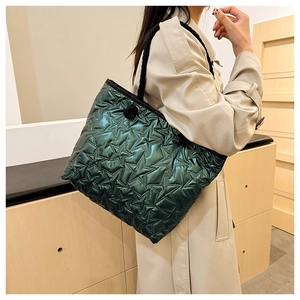 Detail of dark green metallic quilted tote bag with star pattern and rope handle