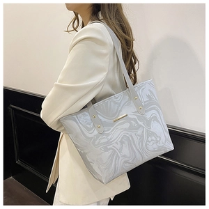 Detail of grey marble textured tote bag with elegant gold metal hardware accents