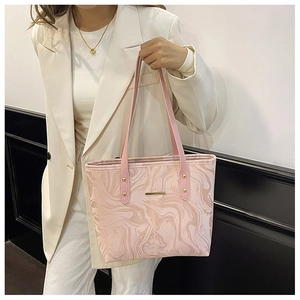 Detail of pink marble pattern tote bag with gold rivets on a white blazer outfit