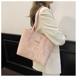 Detail of pink marble pattern tote bag with reinforced handles on white blazer