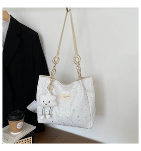 Dettaglio della borsa tote bianca con stelle argento e ciondolo a nuvola di peluche