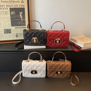 Quilted leather handbags in black, red, white and brown with gold buckles and top handles