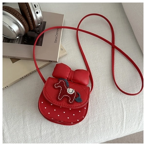 Detail of red girl's crossbody bag with quilted texture, horse embroidery and large bow