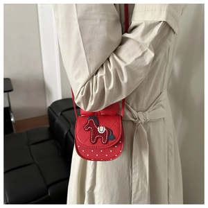 Detail of red girls' crossbody bag with pony embroidery and white heart pattern