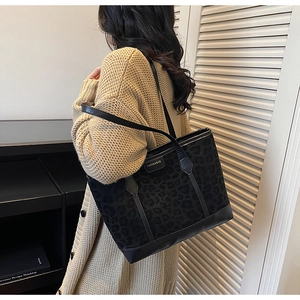 Model wearing a vintage leopard print tote bag with matte texture and leather straps
