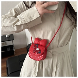 Detail of red quilted child's handbag with large bow and pony embroidery over polka dots