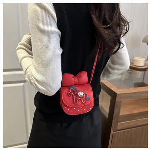 Detail of red girls crossbody bag featuring large bow and cute pony embroidery detail