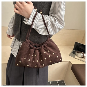 Detail of vintage matte suede bucket bag with gold studs and drawstring pleats