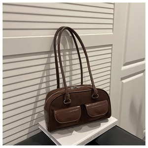 Detail of dark brown suede shoulder bag with glossy leather pockets and silver hardware