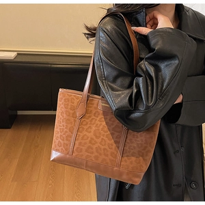 Detail of vintage leopard print tote bag featuring brown faux suede and leather trim