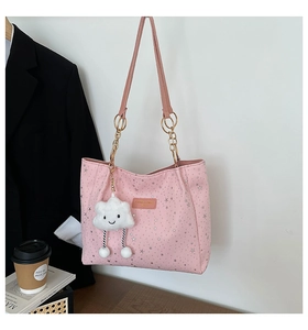 Dettaglio borsa tote rosa con stelle, tracolla in pelle e ciondolo a nuvola