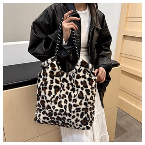 Detail of large leopard print plush tote bag featuring woven patterned shoulder straps