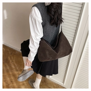 Détail d'un grand sac bandoulière marron avec finition mate et structure souple hobo