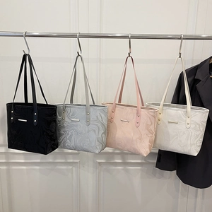 Minimalist marble pattern tote bags in four colors hanging on a metal rack