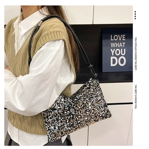 Close-up of sparkling sequin baguette bag with knotted shoulder strap on model