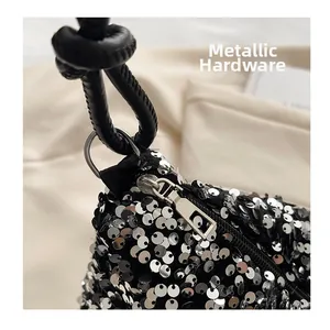 Detail of silver sequins and metallic hardware with a black knotted leather strap