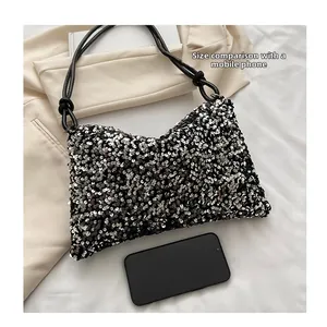 Detailed size comparison of a sequined dumpling bag with a smartphone reference