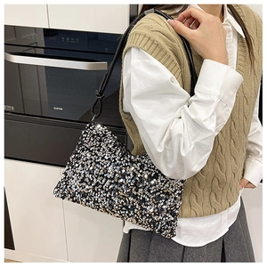 Close-up of a sequin shoulder bag featuring sparkling black and silver color-blocking detail
