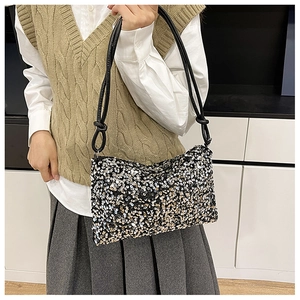 Detail of sequined shoulder bag with black, silver, and champagne gold metallic discs