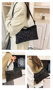Detail of a black sequin shoulder bag with leather knotted strap and glossy texture