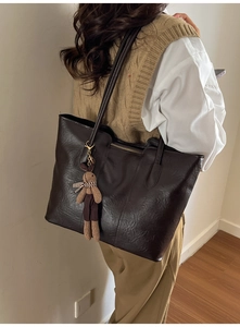 Détail d'un grand sac cabas marron foncé en similicuir texturé avec breloque lapin