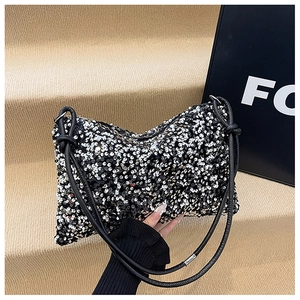 Detail of sequined shoulder bag with black leather straps and decorative knot accents