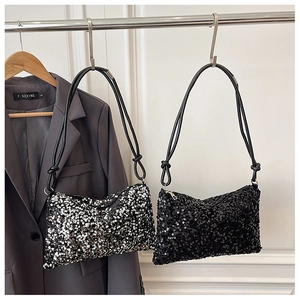 Close-up of sequined shoulder bags in black and silver finishes on a display rack